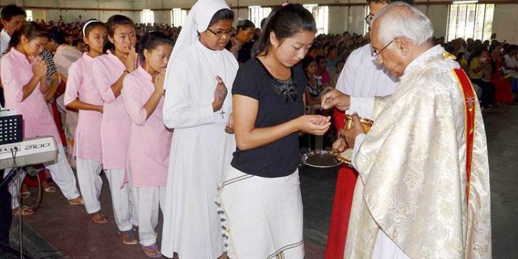 Catholic prist offers Holy Communion during the Easter Sunday Mass at the Holy church in Dimapur, Nagaland (PTI photo)