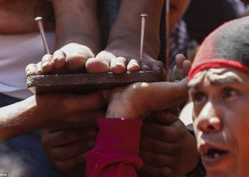 Not faking: Nails are driven through a man's feet in the Philippines as part of that country's traditional celebration of Easter (AFP)