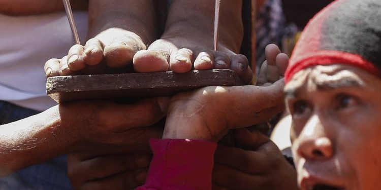 Not faking: Nails are driven through a man's feet in the Philippines as part of that country's traditional celebration of Easter (AFP)