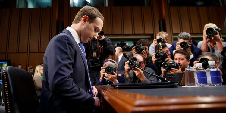 FILE- In this April 10, 2018, file photo Facebook CEO Mark Zuckerberg adjusts his tie as he arrives to testify before a joint hearing of the Commerce and Judiciary Committees on Capitol Hill in Washington. Earlier this month Zuckerberg announced a new “privacy-focused vision” for the company to focus on messaging instead of more public sharing, but he stayed mum on overhauling Facebook’s privacy practices in its core business. (AP Photo/Carolyn Kaster, File)