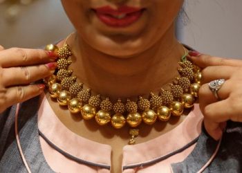 A saleswoman displays a gold necklace to a customer inside a jewellery showroom on the occasion of Akshaya Tritiya, a major gold buying festival, in Mumbai, April 18, 2018. REUTERS/Francis Mascarenhas/Files
