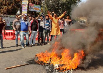 Jammu: Rashtriya Swayamsevak Sangh (RSS) activists raise slogans and burn tyre during a protest against the attack on their party leader Chandrakant Singh, in Kishtwar, Jammu, Tuesday, April 09, 2019. (PTI Photo)(PTI4_9_2019_000085B)
