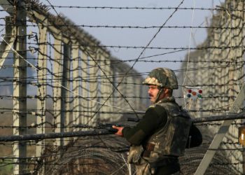 An Indian Border Security Force (BSF) soldier patrols near the fenced border with Pakistan in Suchetgarh, southwest of Jammu January 11, 2013. A flare-up in fighting on the Line of Control dividing India and Pakistan in Kashmir this week has cast a rare light on the low-level manoeuvring by both armies, highlighting the extent to which the nuclear-armed old enemies remain on a knife edge.  REUTERS/Mukesh Gupta (INDIAN-ADMINISTERED KASHMIR - Tags: MILITARY CIVIL UNREST POLITICS)