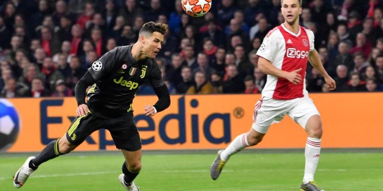 Cristiano Ronaldo of Juventus scores with a flying header as an Ajax Amsterdam defender watches him during the Champions League tie, Wednesday