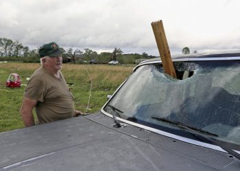 A man looks at a piece of wood that was blown through the windshield of his daughters truck in Hamilton, Miss., after a storm moved through the area Sunday, April 14, 2019. (AP Photo/Jim Lytle)