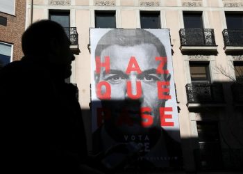FILE PHOTO - A man walks past an electoral poster of Spain's Socialist (PSOE) leader and current Prime Minister Pedro Sanchez outside the PSOE headquarters in Madrid, Spain, April 12, 2019. REUTERS/Susana Vera