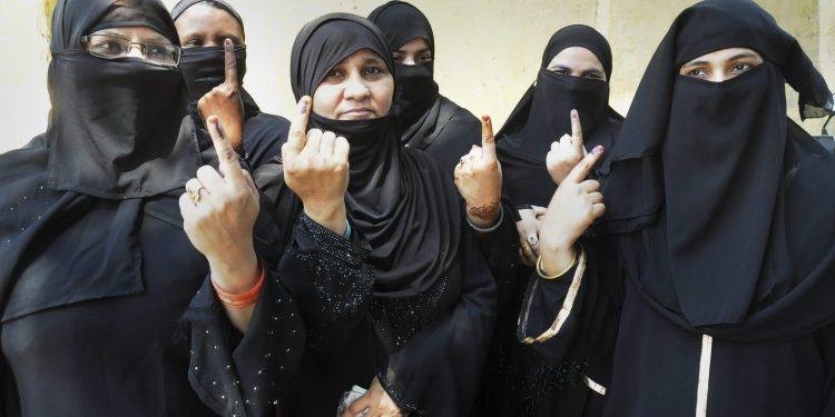 Burqa-clad women show their inked fingers after casting their votes at Moradabad in the third phase of the Lok Sabha polls, Saturday