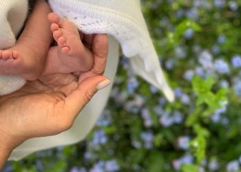 In this undated photo made available on Sunday, May 12, 2019 by @SussexRoyal, Meghan the Duchess of Sussex holds the feet of her baby, Archie Harrison Mountbatten-Windsor. Prince Harry and Meghan, the Duchess of Sussex, have released a photo of their newborn baby to mark Meghan‚Äôs first Mother‚Äôs Day as a mom. The image posted on Instagram shows her hand cradling the feet of Archie Harrison Mountbatten-Windsor, who was born on Monday, against a bed of spring flowers. (@SussexRoyal via AP)