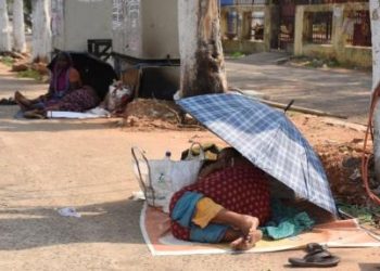 A woman uses an umbrella to save herself from the heat