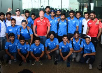 Coach Graham Reid (Centre, in red shirt) with the Indian players after their arrival in Bhubaneswar, Sunday