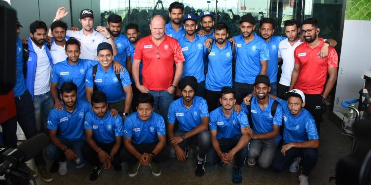 Coach Graham Reid (Centre, in red shirt) with the Indian players after their arrival in Bhubaneswar, Sunday