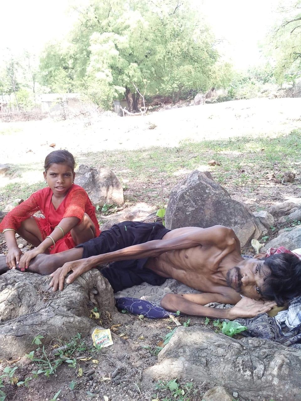 Baidhar and his minor daughter Suchitra taking shelter under a tree, Saturday