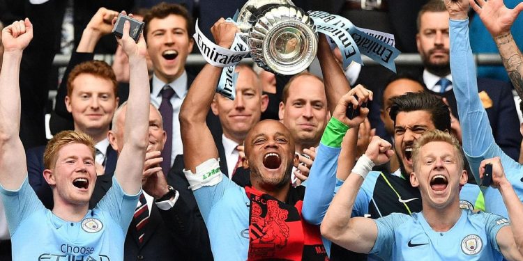 Manchester City players celebrate with the FA Cup after their win Saturday
