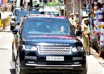 Narendra Modi waves to the crowd after arriving in Varanasi, Monday