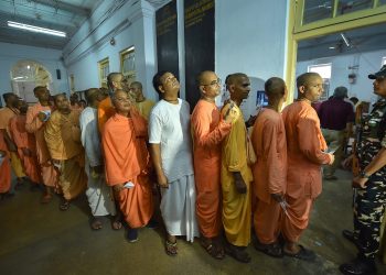 Members of ISKCON wait to cast their votes for the seventh and last phase of Lok Sabha elections, at a polling booth in Kolkata, Sunday