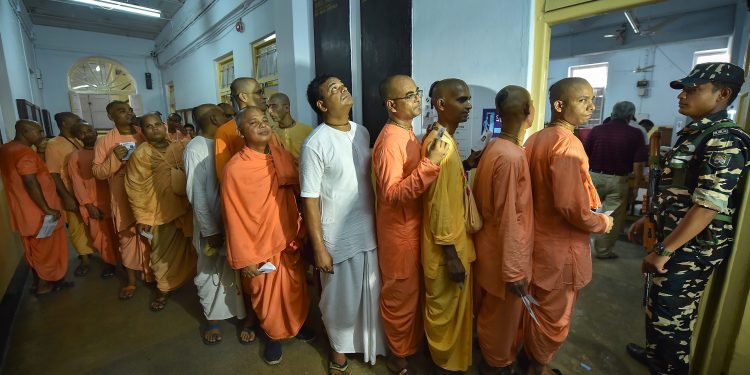 Members of ISKCON wait to cast their votes for the seventh and last phase of Lok Sabha elections, at a polling booth in Kolkata, Sunday