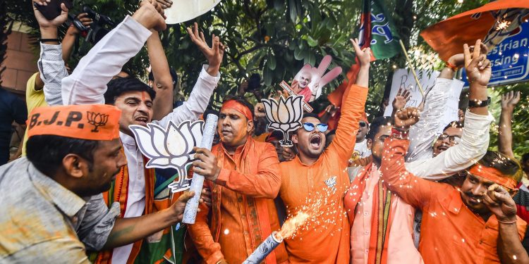 BJP workers celebrate their party's landslide win at the office of the saffron party in New Delhi