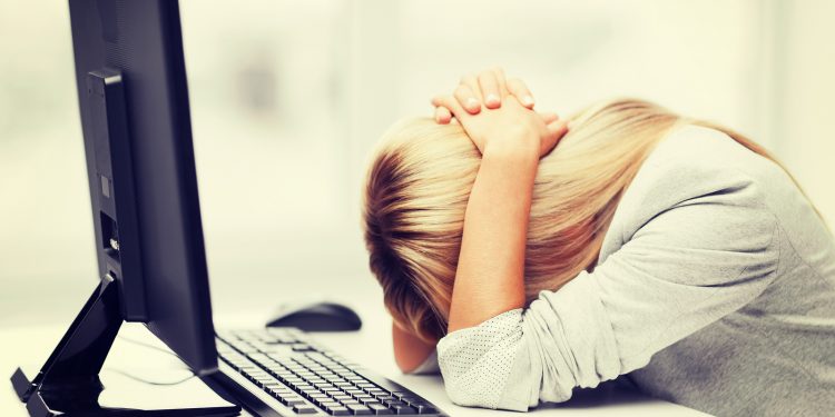 business, office, school and education concept - stressed businesswoman with computer at work