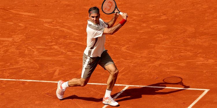 Roger Federer plays a backhand during his match at Roland Garros