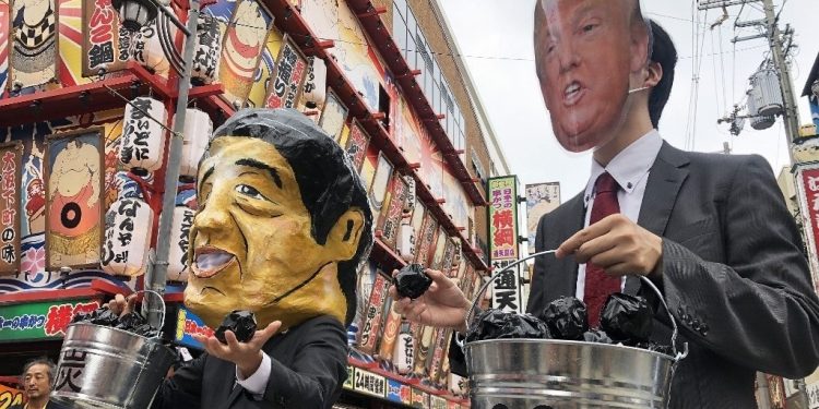 Protesters wearing masks of world leaders including a giant paper mache Japanese Prime Minister Shinzo Abe (L) and US President Donald Trump demonstrate against climate change and coal use, at Osaka in Japan