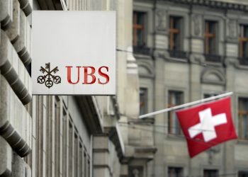 A Swiss flag is seen behind a sign of Swiss bank giant UBS on June 11, 2013 in Basel.  AFP PHOTO / FABRICE COFFRINI        (Photo credit should read FABRICE COFFRINI/AFP/Getty Images)