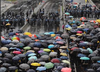 Protesters holding umbrellas face off against police officers  in Hong Kong Monday, July 1, 2019.