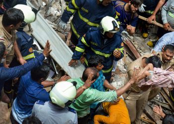 A child being brought out from under the debris by rescue personnel at the site of the Dongri building collapse