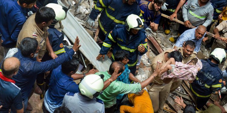 A child being brought out from under the debris by rescue personnel at the site of the Dongri building collapse