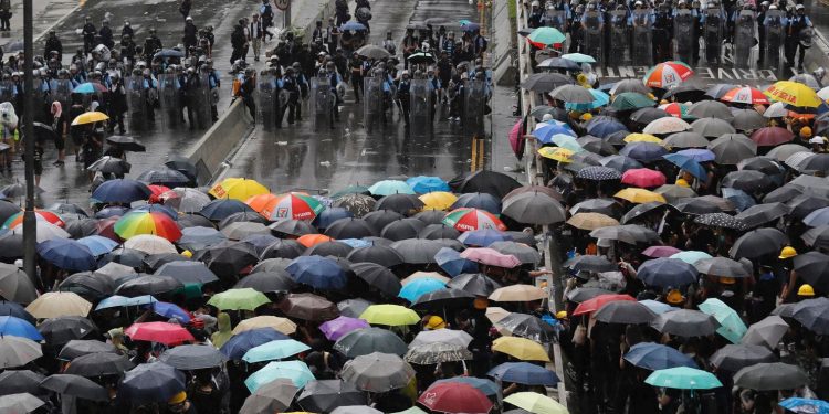 Protesters holding umbrellas face off with police officers in anti-riot gear in Hong Kong July 1. (Kin Cheung/AP)