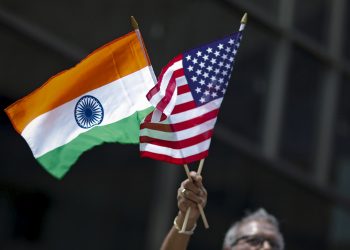 A man holds the flags of India and the U.S. while people take part in the 35th India Day Parade in New York August 16, 2015. REUTERS/Eduardo Munoz - GF20000022053