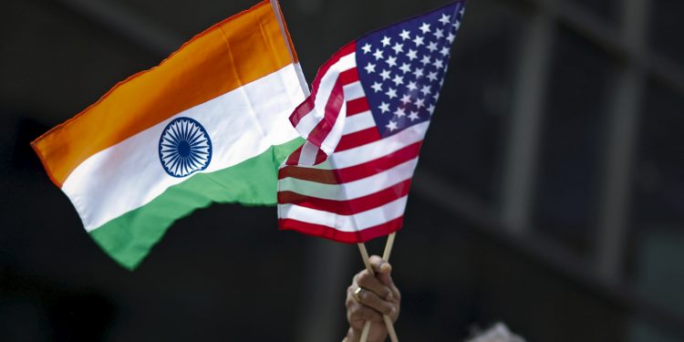 A man holds the flags of India and the U.S. while people take part in the 35th India Day Parade in New York August 16, 2015. REUTERS/Eduardo Munoz - GF20000022053
