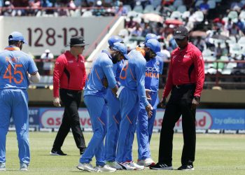 Indian players and umpires inspect the pitch after a rain break during their first ODI match against The West Indies, Thursday in Providence