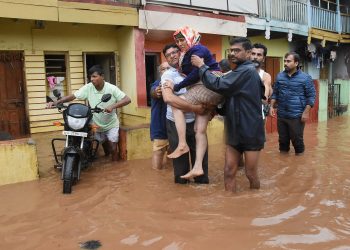 An elderly woman being carried to safety in Kerala's Wayanad district