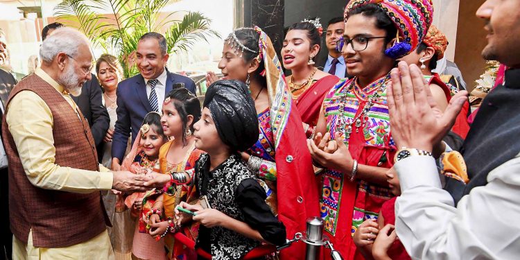 Prime Minister Narendra Modi reacts with Indian people in Manama