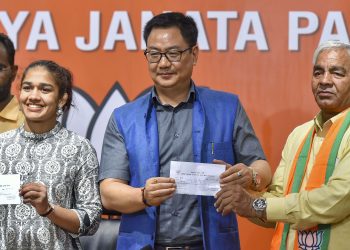 Babita Phogat and her father Mahavir Phogat with Union Sports and Youth Affairs Minister Kiren Rijiju