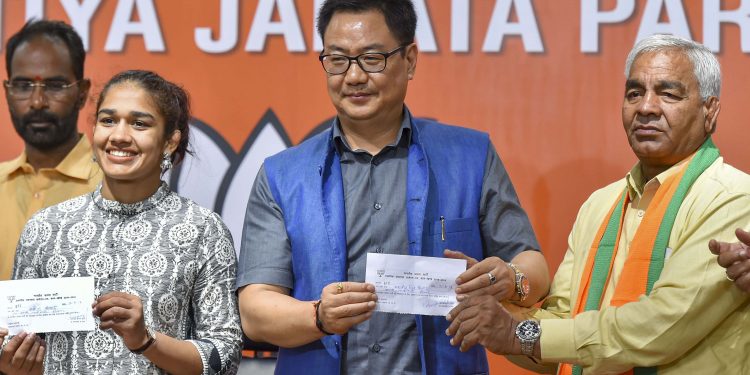 Babita Phogat and her father Mahavir Phogat with Union Sports and Youth Affairs Minister Kiren Rijiju