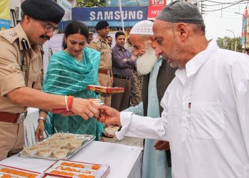 Security personnel offer sweets to residents of Jammu after the prayers Monday