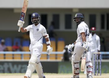 Ajinkya Rahane raises his bat after his century against the West Indies, Sunday