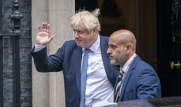 UK Prime Minister Boris Johnson (L) with an aide