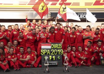 Charles Leclerc (with cap) poses with the Ferrari team after his maiden Formula One win, Monday