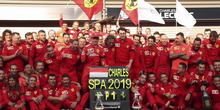 Charles Leclerc (with cap) poses with the Ferrari team after his maiden Formula One win, Monday