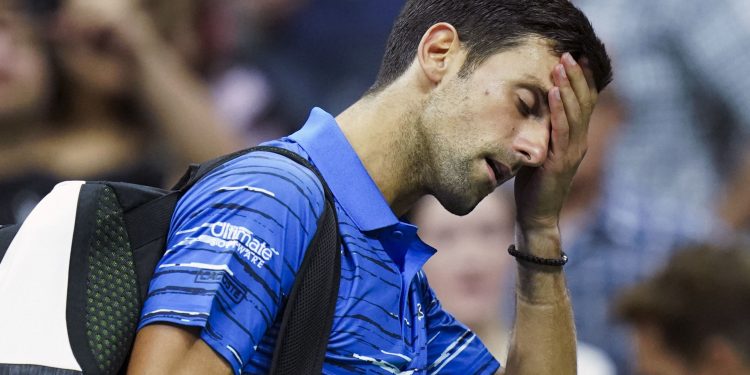 A disappointed Novak Djokovic walks off the court at the US Open, Sunday