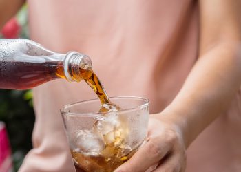 Glass of cola - Soft drinks with ice being poured.