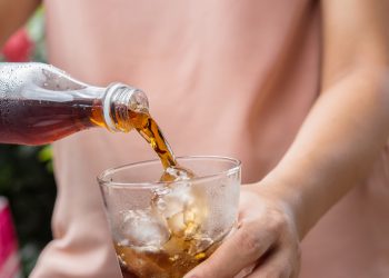 Glass of cola - Soft drinks with ice being poured.