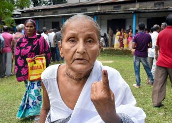 An elderly woman shows off her inked finger after casting her vote in the Rangapara Assembly constituency in Assam
