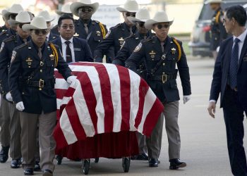 The coffin of slain cop Sandeep Singh Dhaliwal draped in an American flag being carried for funeral