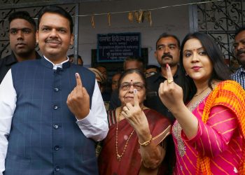 Maharashtra Chief Minister Devendra Fadnavis and his wife Amruta Fadnavi show their fingers marked with indelible ink after casting their votes during Maharashtra Assembly elections, in Nagpur