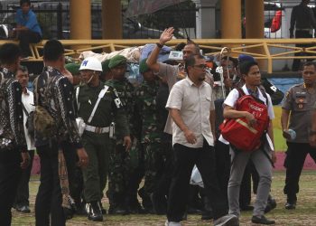 Indonesian minister Wiranton being carried on a stretcher after being stabbed