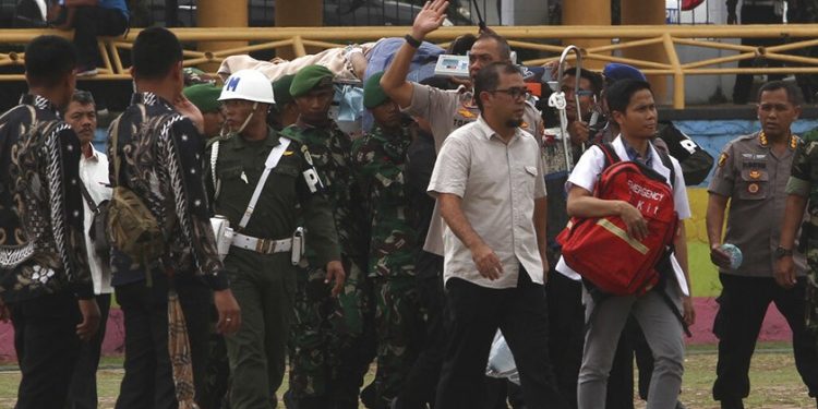 Indonesian minister Wiranton being carried on a stretcher after being stabbed