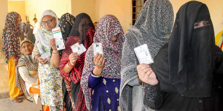 Women voters queue up at a polling booth in Faridabad